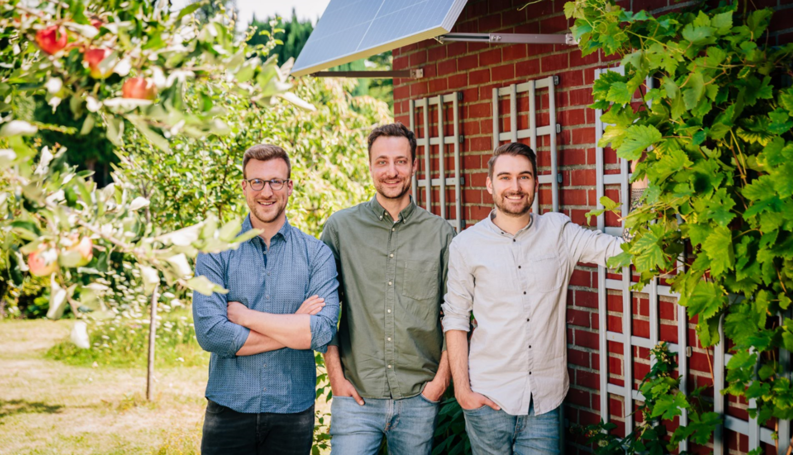 Yuma Teamfoto zeigt drei nebeneinander stehende lächelnde Männer. Sie stehen unter einer Solarpanele.