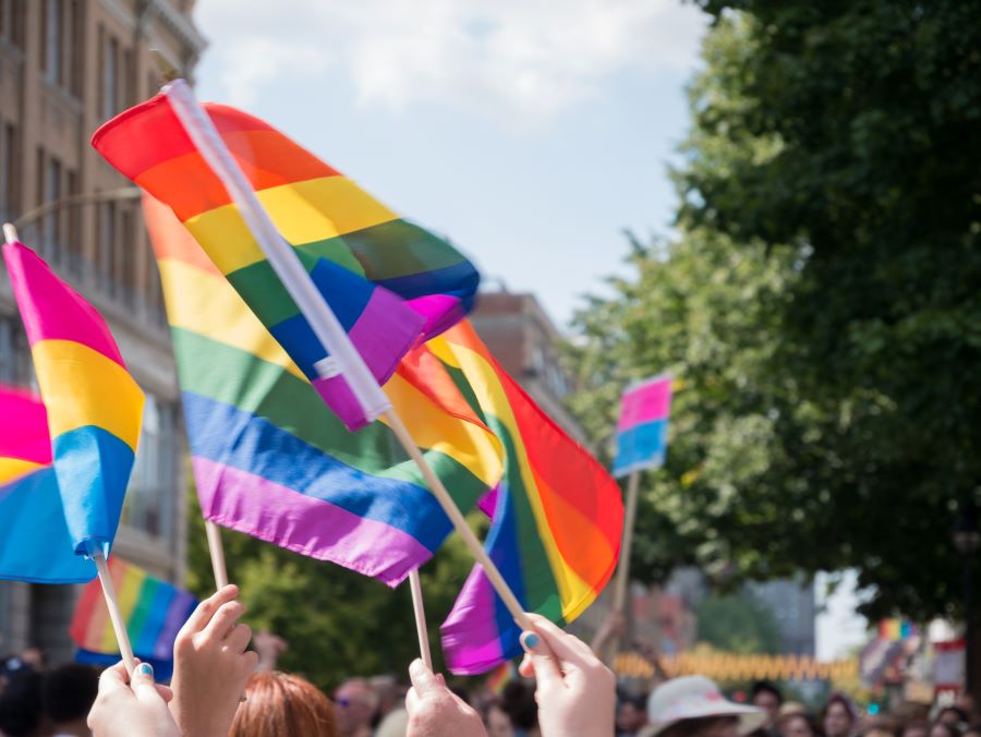 Menschen halten LGBTQI+ Regenbogenflaggen hoch.